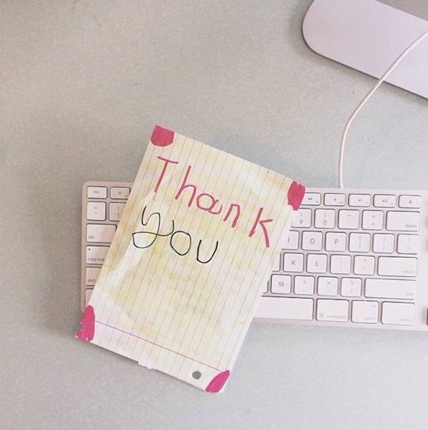 Thank you note laying on a keyboard.