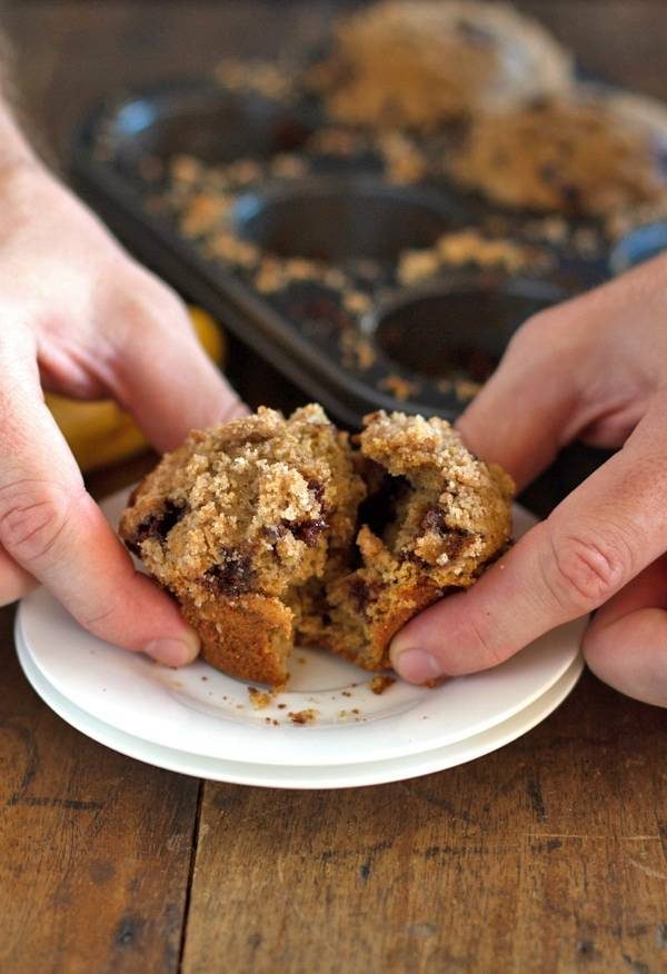Whole wheat chocolate chip banana peanut butter muffin pulled apart on a plate.