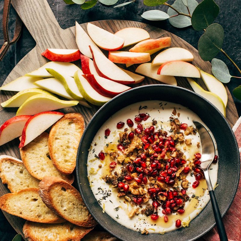 Whipped feta with crackers and fruit on a platter.