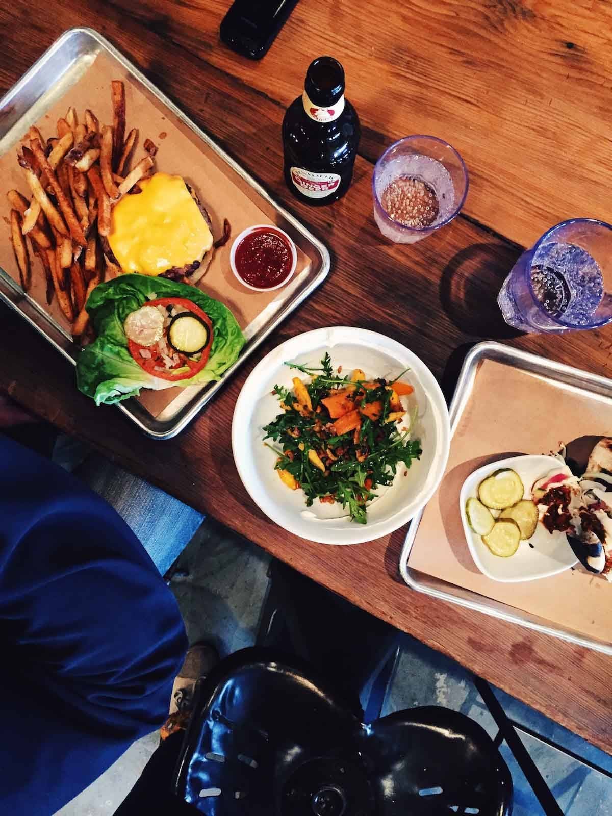 Table with plates and trays of food.